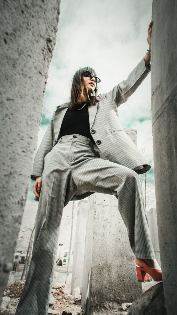 woman in gray coat sitting on concrete bench